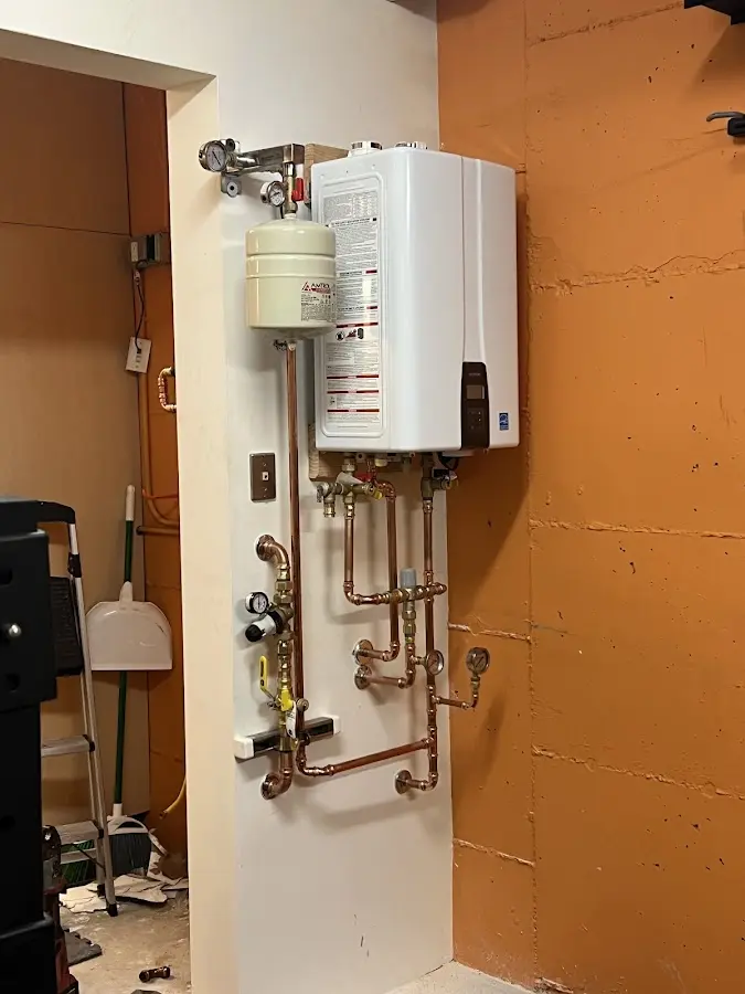 Plumbing technician inspecting water heater connections in Louisburg